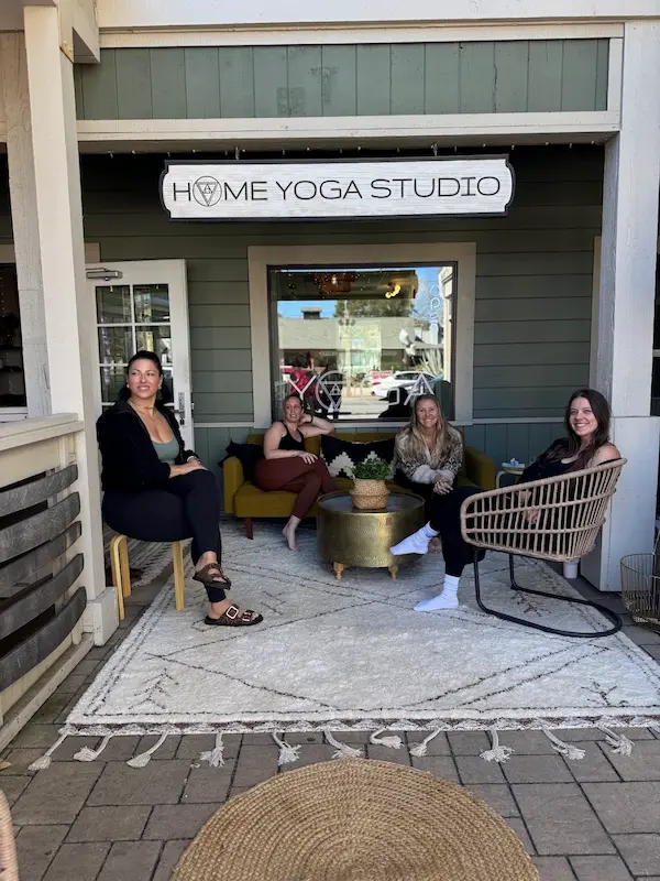 Home Yoga Studio storefront with four women seated outside